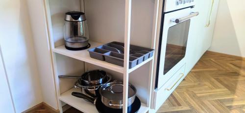 a cupboard with pots and pans in a kitchen at Gästehaus Wallner in Velden am Wörthersee