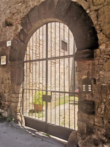 a window in a stone wall with a gate at Casa del Palazzo del Marchese in Tarquinia