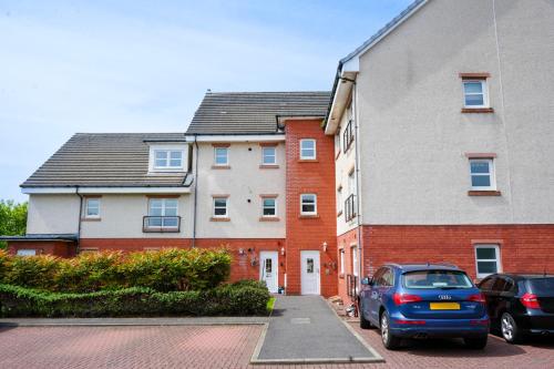 a car parked in a parking lot next to a building at Modern Apartment Ayr Town Centre in Prestwick