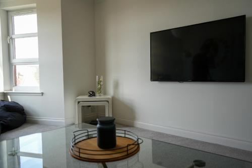 a living room with a flat screen tv on a wall at Modern Apartment Ayr Town Centre in Prestwick