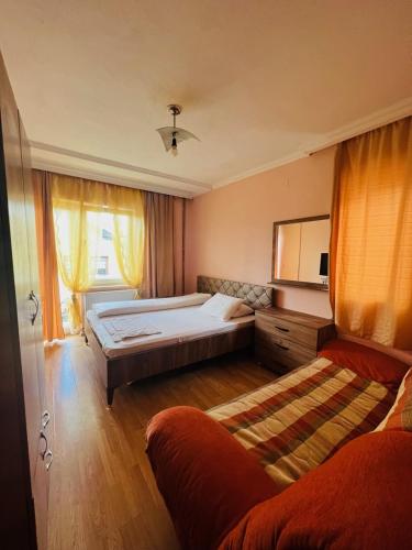 a bedroom with a large bed and a couch at Guest House Velania in Prishtinë