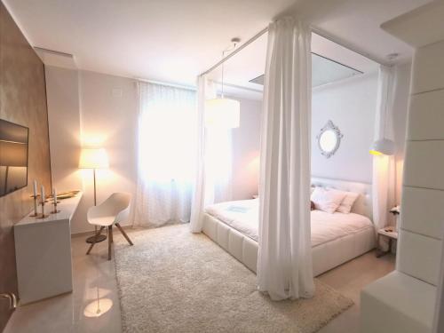 Donji Babići的住宿－Villa Santo，白色卧室配有天蓬床和书桌