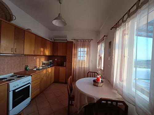 ティノス・タウンにあるSea view Cycladic houseのキッチン(テーブル、コンロ、窓付)
