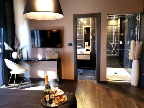Donji Babići的住宿－Villa Santo，带淋浴的浴室以及带一瓶香槟的桌子。
