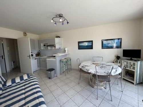un salon avec une table et une cuisine dans l'établissement Appartement 2 pièces avec balcon, vue mer latérale - FR-1-224C-301, à Saint-Jean-de-Monts