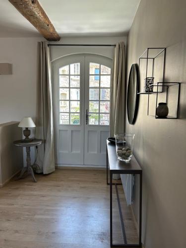 Cette chambre dispose d'une porte et d'une table avec un vase. dans l'établissement Sur le Pont, à Vaison-la-Romaine