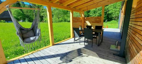 a porch with a hammock and a table and chairs at Pod Beskydem, Velké Karlovice in Velké Karlovice