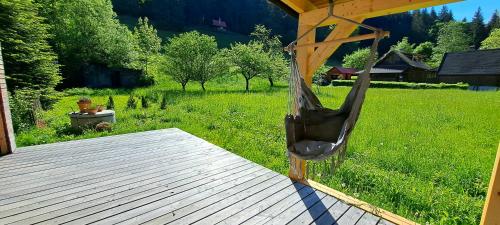 a wooden deck with a hammock on a green field at Pod Beskydem, Velké Karlovice in Velké Karlovice