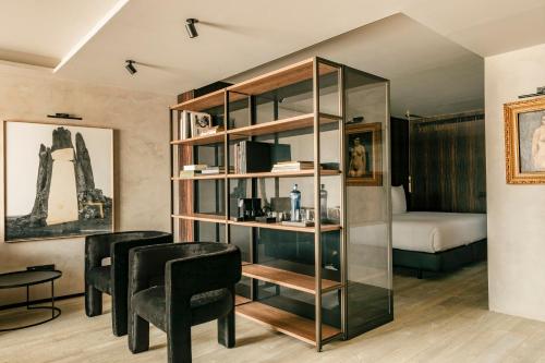 a living room with a book shelf and a bed at Hotel Bagués, a Small Luxury Hotel of the World in Barcelona