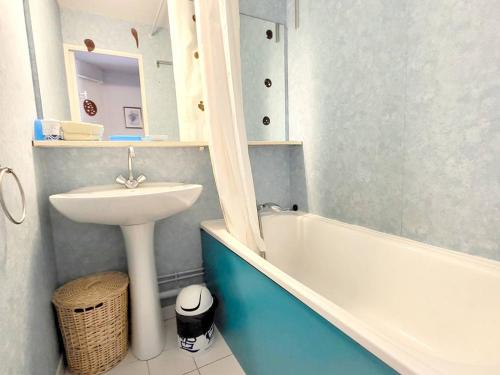 une salle de bain avec un lavabo et une baignoire et un lavabo dans l'établissement T2 à 200m des plages et commerces avec piscine, tennis et parking privatif - FR-1-316-293, à Six-Fours-les-Plages