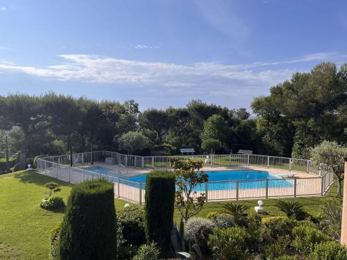 une grande piscine entourée d'une clôture. dans l'établissement Studio calme avec piscine, parking privé, et accès proche à la mer - 4 couchages - FR-1-226A-125, à Fréjus