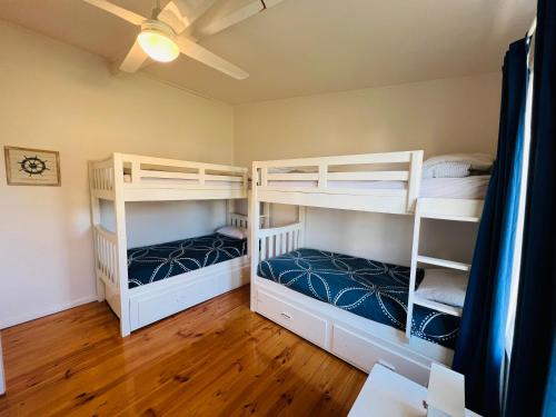 two bunk beds in a room with wooden floors at Teddy's Shack - Pet Friendly in Robe