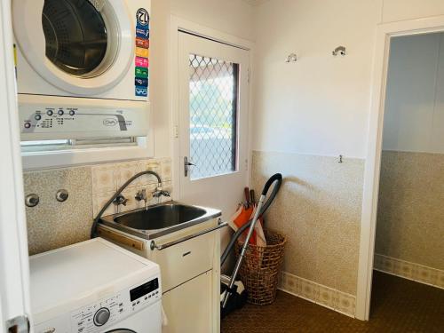 a small kitchen with a sink and a microwave at Teddy's Shack - Pet Friendly in Robe