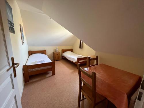 une petite chambre avec deux lits et une table dans l'établissement Les hublots - appartement vue mer, à Wimereux