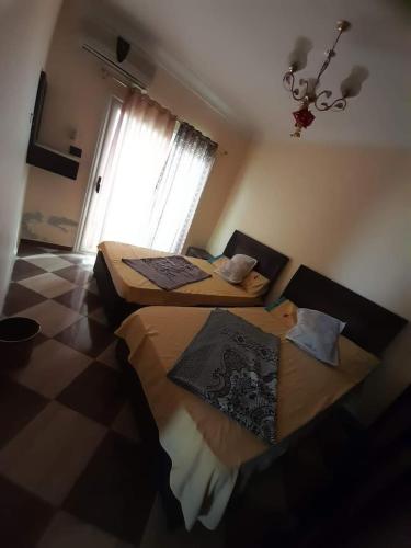 two beds in a room with a window at برج قصر السعد للشقق الفندقية in Marsa Matruh
