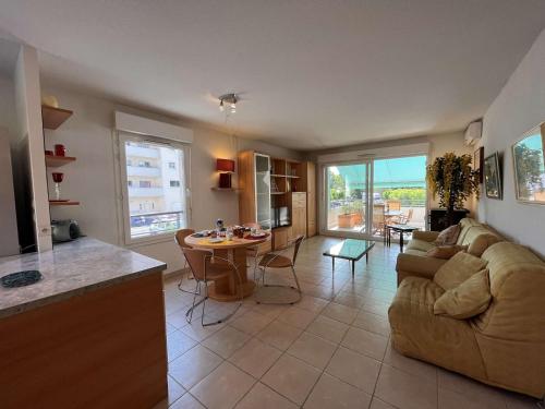 une cuisine et un salon avec un canapé et une table dans l'établissement Appartement Lumineux à 1,5 km de la Plage avec 2 Terrasses - Fréjus - FR-1-226A-159, à Fréjus