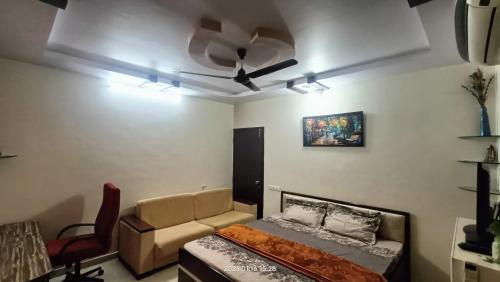 a living room with a couch and a ceiling fan at Gaurang Homestay in Vadodara