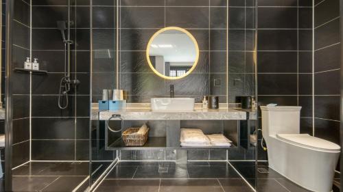 a bathroom with a sink and a mirror at Gong Xili Qingdu Hotel in Shangri-La