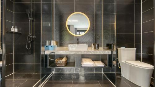 un bagno con lavandino e specchio di Gong Xili Qingdu Hotel a Shangri-La