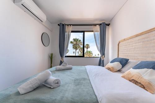 Un dormitorio con una cama grande y una ventana en Charming apartment near beach, sea view terrace, en Torremolinos