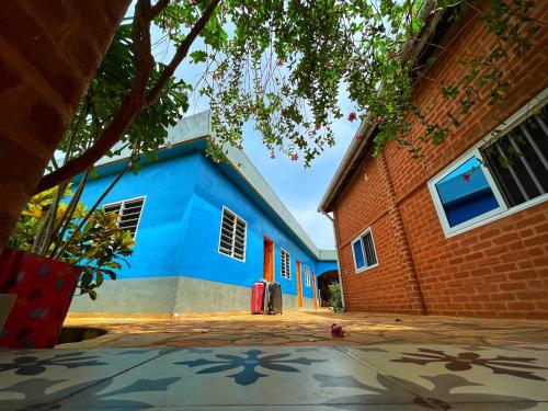un edificio azul junto a un edificio de ladrillo en Maison Charlotte Forever Chambre d'hôtes chez un couple belgo togolais en Lomé