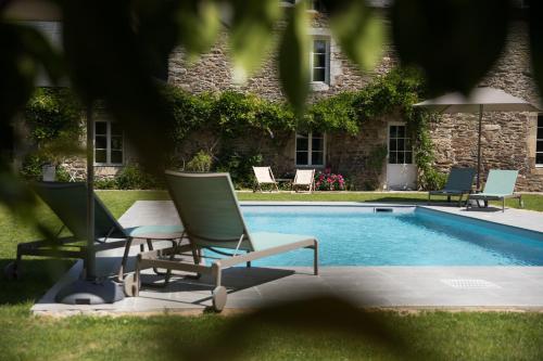 a group of chairs and a swimming pool at MANOIR DU VAU D ARZ gîtes et chambres d hôtes avec piscine in Malansac