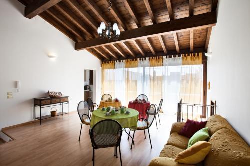 Una sala de estar con un sofá y una mesa con sillas. en B&B Perla del Sud, en Collepasso