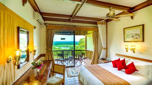 a hotel room with a bed and a balcony at Paraa Safari Lodge in Paraa