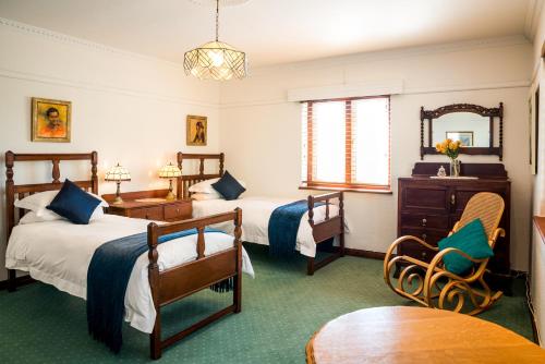 una camera d'albergo con due letti e un tavolo di The Upper Deck at Sunny Cove a Fish Hoek