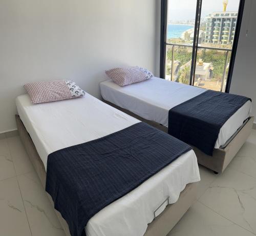 2 camas en una habitación con ventana grande en Résidence Boutique XV Alanya Bay, Vue exceptionnelle sur Mer en Kargicak
