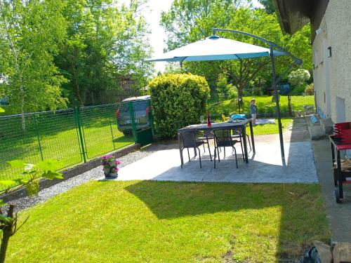 a patio with a table and an umbrella at Apartmán u Vrbů in Černá v Pošumaví