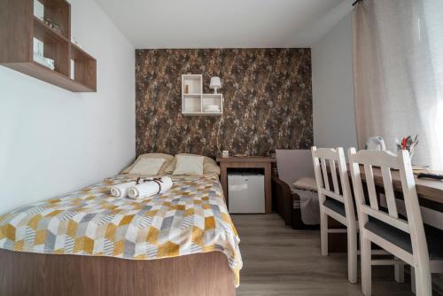 a bedroom with a bed and a desk and chairs at Pokoje Iga in Władysławowo