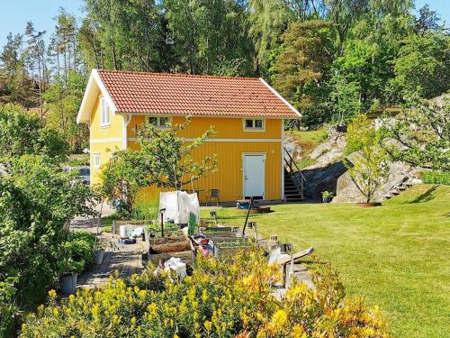 ein kleines gelbes Haus auf einem Feld mit einem Hof in der Unterkunft 4 person holiday home in ELL S in Ellos