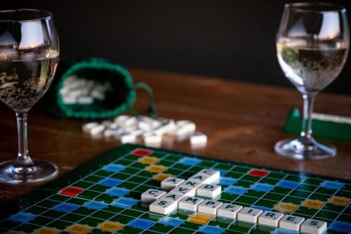 a chess board and two glasses of wine on a table at Canvas & Campfires, Luxury Safari Tent Glamping, only Seren Tent has a hot tub in Lampeter