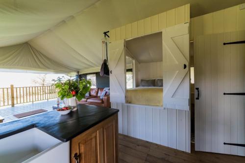 eine Küche und ein Wohnzimmer mit einem Bett in einem Zelt in der Unterkunft Canvas & Campfires in Lampeter