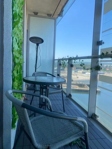 a table and a chair on a balcony at Water view harbour in Glasgow