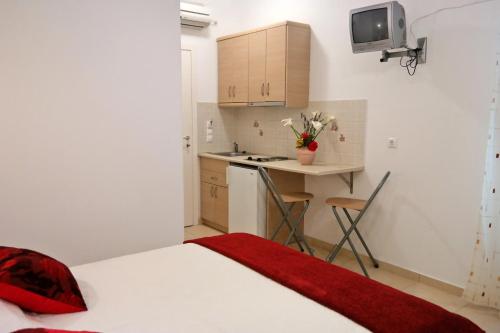 a bedroom with a bed and a small kitchen at Magic Land in Plaka