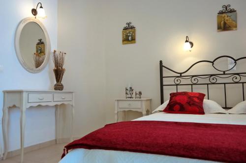 a bedroom with a bed with a red pillow and a mirror at Magic Land in Plaka