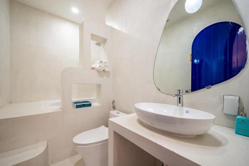 a bathroom with a sink and a toilet and a mirror at Happiness Hotel in Quy Nhon