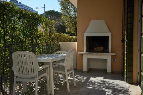 a patio with a table and chairs and a fireplace at Appartamenti Villa Paola-Pochi passi dal mare-Zona piazza Aurora-Lido di Jesolo in Lido di Jesolo