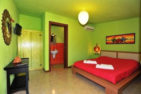 a green bedroom with a red bed and a bathroom at Butterfly House Bed & Breakfast in Alghero