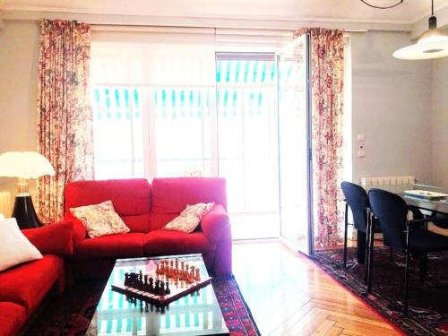 a living room with a red couch and a table at Apartamento Miramar in Hondarribia