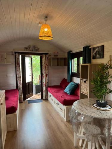 un salon avec deux lits et une table dans l'établissement La Roulotte du Mas, à Saintes-Maries-de-la-Mer
