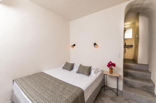 a white bedroom with a bed and a staircase at Amvikas suites-Sitia, by Comfortbnb in Sitia