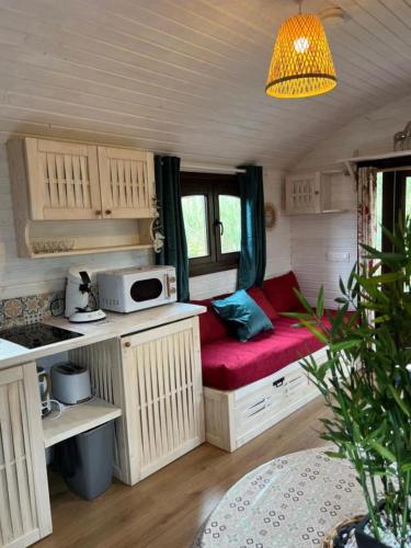 une petite cuisine avec un banc rouge dans une caravane dans l'établissement La Roulotte du Mas, à Saintes-Maries-de-la-Mer