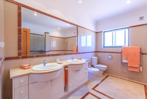 a bathroom with two sinks and a toilet at Casa Atlantico in Quinta do Lago