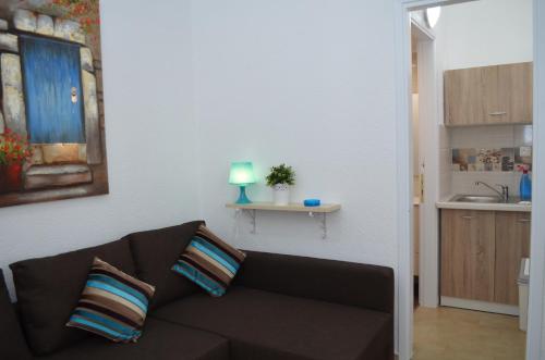 ein Wohnzimmer mit einem Sofa und einer Küche in der Unterkunft Rania Bella Vista Studios in Poros