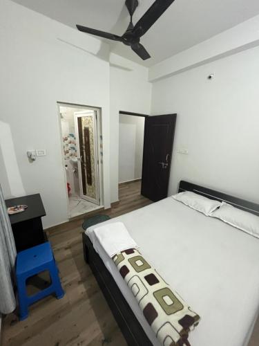 1 dormitorio con 1 cama y ventilador de techo en Marigold Hotel, en Siliguri