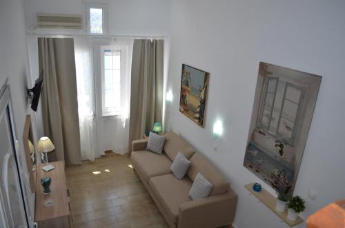 ein Wohnzimmer mit einem Sofa und einem Tisch in der Unterkunft Rania Bella Vista Studios in Poros
