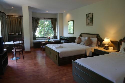 a hotel room with two beds and a living room at Chaweng Tara Hotel in Chaweng Noi Beach